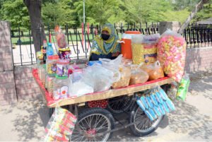 Woman Vendor Offers Snacks on Handcart at Multan’s General Bus Stand Road