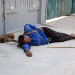 Juggler and Pet Monkey Rest Amid Scorching Heat in Multan