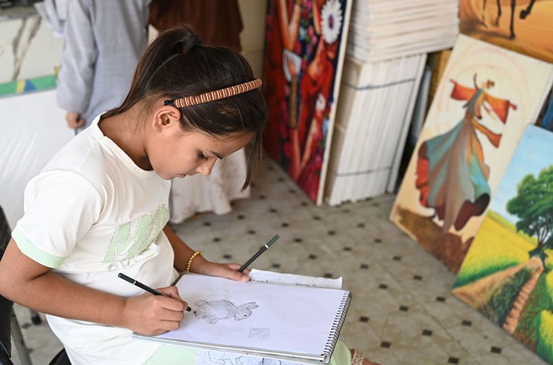 Girl Participates in Sketching Activity at Islamabad Weekly Bazaar