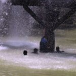 Youth Bathes in Leaking Canal Water Amid Intense Heatwave