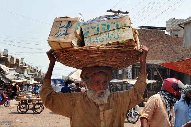 Elderly Laborer Endures Heat in Bustling Market