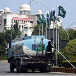 CDA Worker Tends to Green Belt Near Parliament House