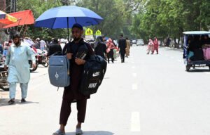 Street Vendor Sells School Bags Under Umbrella in Lahore