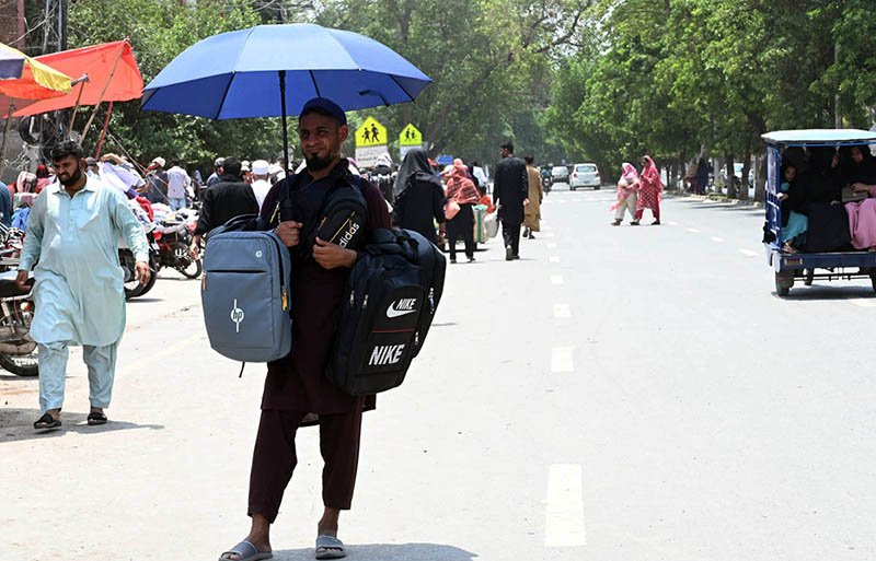 Street Vendor Sells School Bags Under Umbrella in Lahore