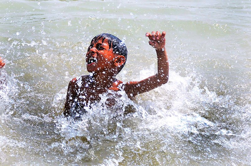 Youth Seeks Relief from Heatwave in City Canal