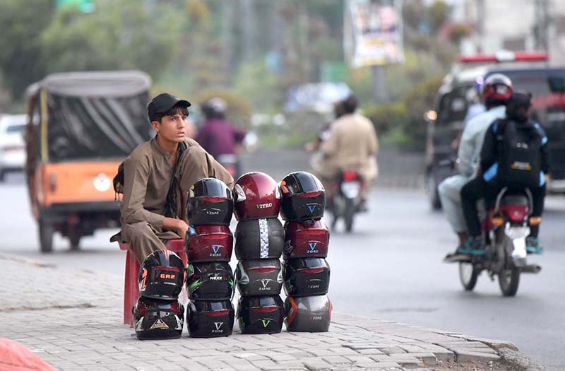 Street Vendor Sells Safety Helmets Amid Traffic Concerns on Murree Road