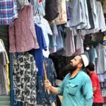 Vendor Displays Colorful Shirts to Attract Shoppers at Lahore’s Anarkali Bazaar