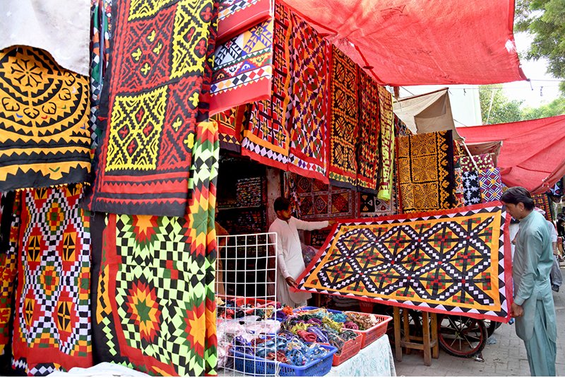 Larkana Vendors Showcase Traditional Patchwork Bed Sheets to Customers